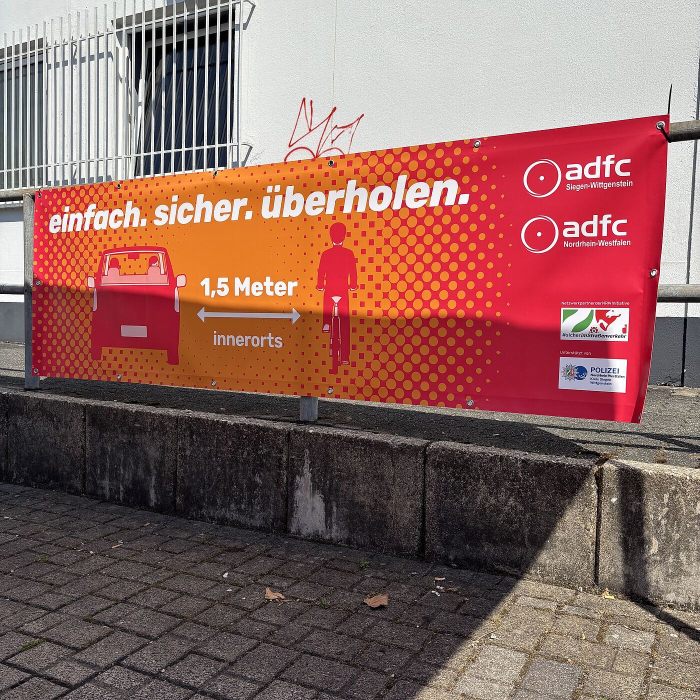 Ein Banner weist auf den gesetzlich vorgeschriebenen Überholabstand von 1,5 Metern innerorts hin.