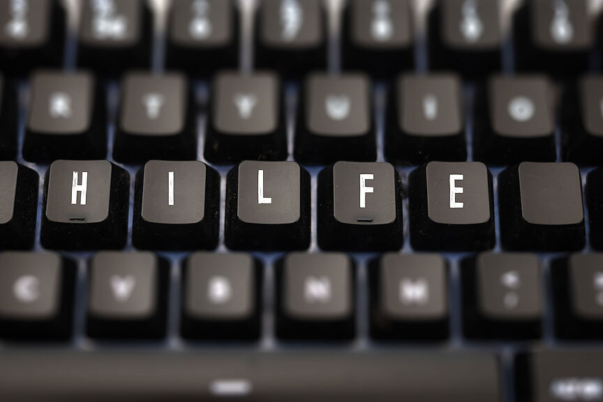 Help word written on keypad. Black keys with white letters message for assistance on pc keyboard. Blur buttons background.