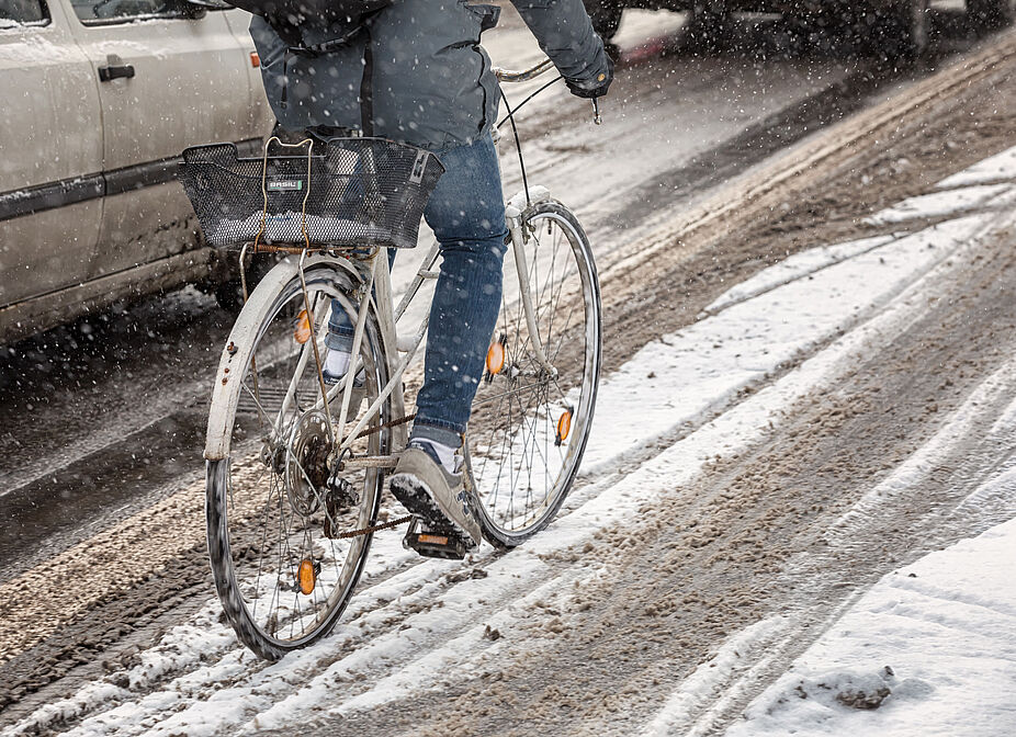 Geräumte Radwege begünstigen Radfahren im ganzen Jahr Radfahrer im Schnee im Straßenverkehr